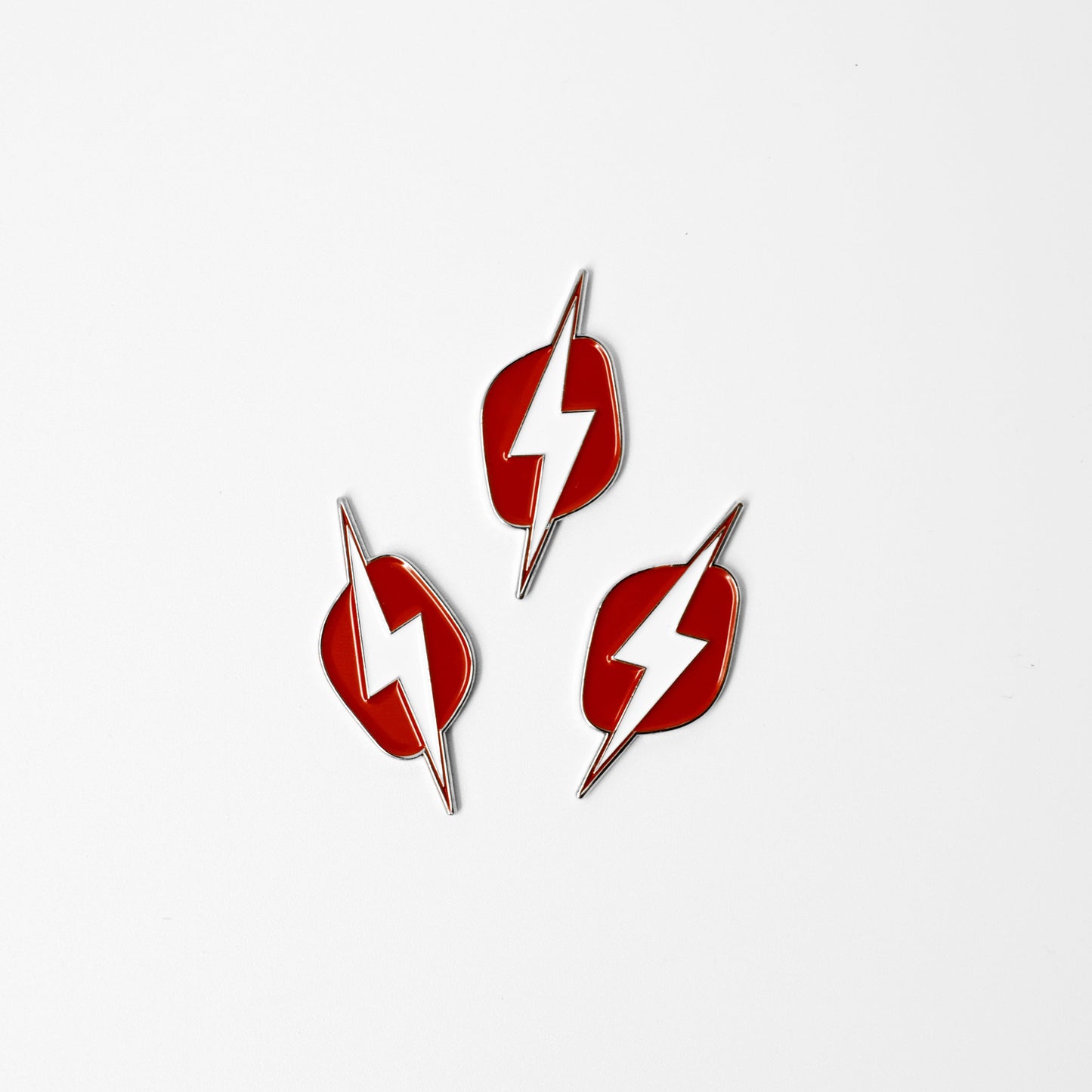 
                  
                    Three red lightning bolt-shaped earrings on a white background
                  
                