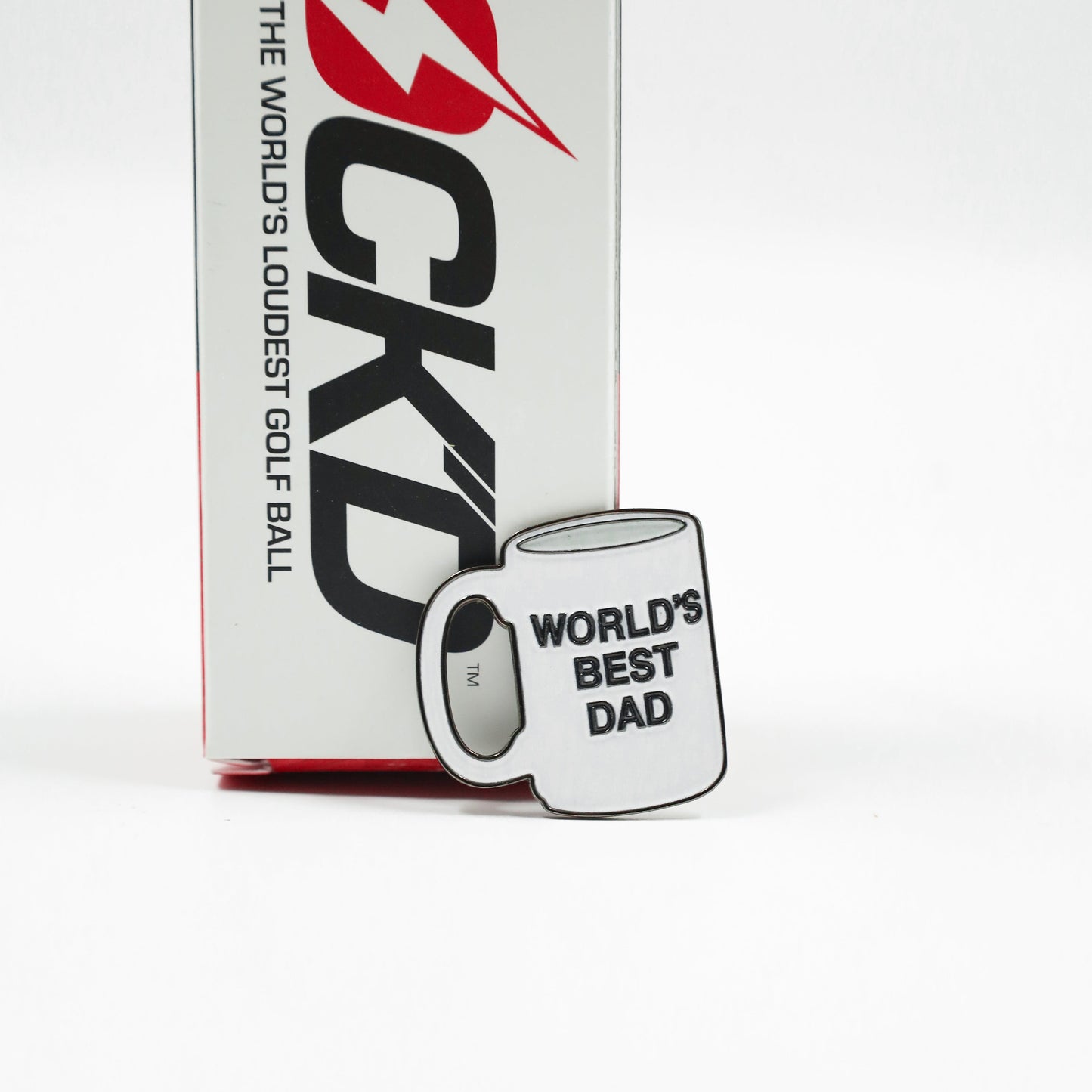Golf ball box with 'World's Loudest Golf Ball' text and a mug labeled 'World's Best Dad' on a white background.