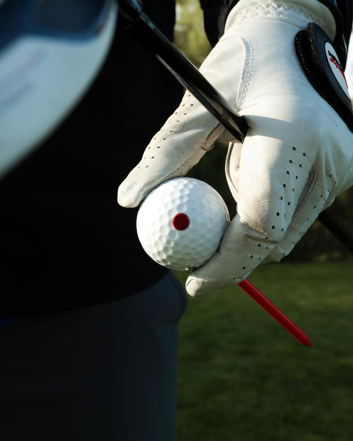 SHOCK'D golf ball held on a tee