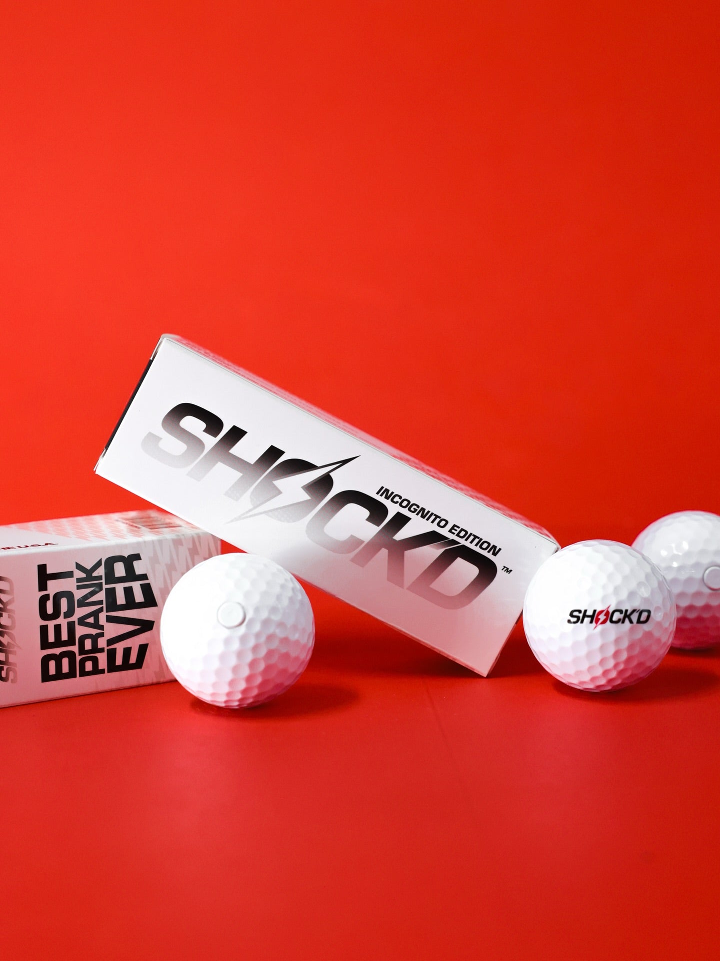 SHOCK'D Golf Balls in sleeve on grass with a driver
